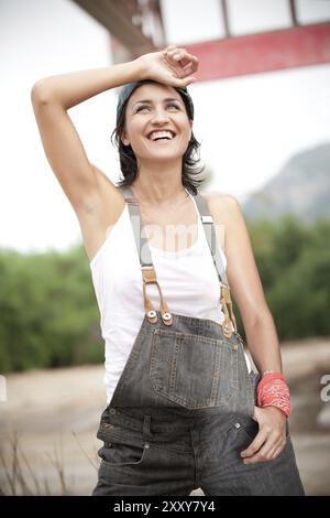 Hübsche Frau in Denim-Overalls Stockfoto