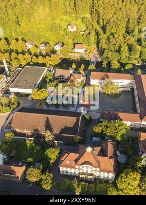 Aus der Vogelperspektive auf ein Viertel mit mehreren Gebäuden und viel Grün, umgeben von Bäumen und Hügeln dahinter, Nagold, Schwarzwald, Deutschland, Europ Stockfoto