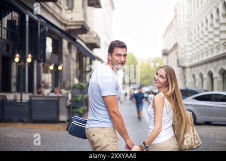 Glückliches Paar in Liebe zu Fuß in die Stadt Tbilisi, Georgia. Junge Erwachsene Touristen unterwegs Stockfoto