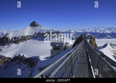 Winterszene auf dem Glacier des Diablerets. Oldenhorn. Hängebrücke, die zwei Berggipfel verbindet. Gipfelstation einer Seilbahn Stockfoto