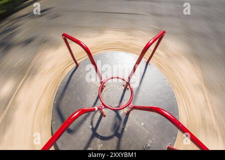 Auf einem roten Karussell auf einem Spielplatz stehen Stockfoto