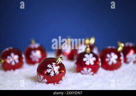 Weihnachtsbaumschmuck im Schnee auf blauem Hintergrund Stockfoto