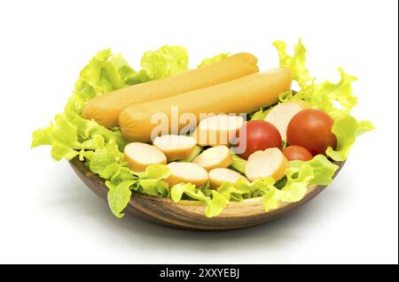 Würstchen, Salat und Tomaten in Houten auf weißem Hintergrund Stockfoto