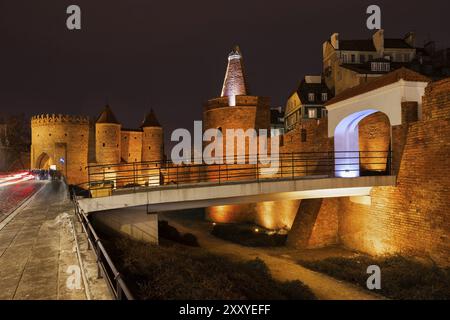 Polen, Warschau, Stadtmauerbefestigung mit dem Barbican bei Nacht beleuchtet, Fußgängerbrücke und Tor zur Altstadt, Europa Stockfoto