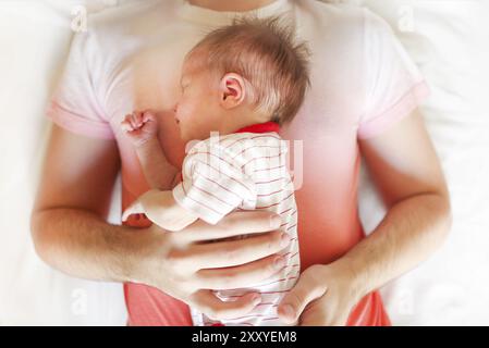 Blick von oben auf die stattlichen Vater schlafend auf dem Bett mit neugeborenen Tochter Stockfoto