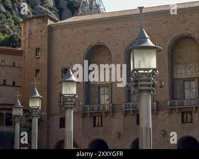 Historisches Gebäude mit Laternen und Kreuzen, eingebettet in eine felsige Landschaft, montserrat, spanien Stockfoto