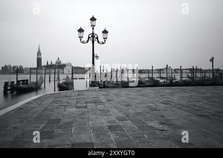 Schwarzweiß-Foto von Venedig am Meer mit Gondeln auf den Wellen. Venedig, Italien, Europa Stockfoto