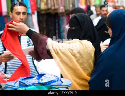 Verschleierte Frauen, die durch die pulsierenden Basare in Kairo, Ägypten, spazieren. Stockfoto