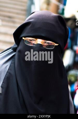 Eine verschleierte Frau, die durch die pulsierenden Basare in Kairo, Ägypten, spaziert. Stockfoto