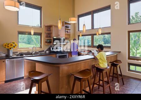 Warme, sonnige Küche mit vielen großen Fenstern in Passivsolarhaus Stockfoto