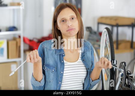 Eine Frau versucht, das Fahrrad zu reparieren Stockfoto