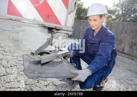 Arbeiterinnen, die den Kranfuß stabisieren Stockfoto