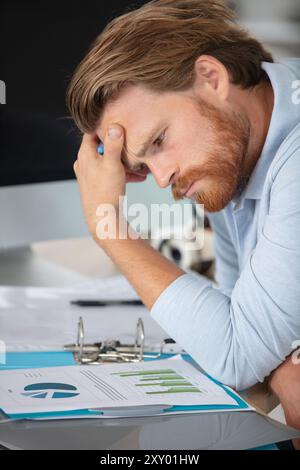 Junger Geschäftsmann, der sich mit Grafiken beschäftigt Stockfoto