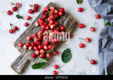 Fresh ripe red cherries in bowl on white stone background, heap of summer fruits concept Stockfoto