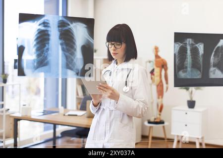 Arzt, der Röntgenaufnahmen auf einem digitalen Tablet im Krankenhaus analysiert Stockfoto