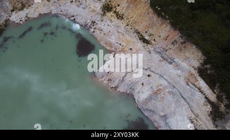 Überfluteter Steinbruch, fotografiert von einer Drohne. Das Wasser ist mit Kaolin. Deshalb hat das Wasser eine milchige Farbe Stockfoto