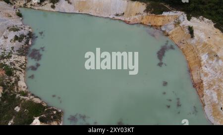 Überfluteter Steinbruch, fotografiert von einer Drohne. Das Wasser ist mit Kaolin. Deshalb hat das Wasser eine milchige Farbe Stockfoto