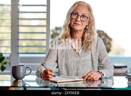Porträt, reife Frau und Heimat als Autorin mit Zeitschrift im Schreibtisch für Romanverlag als freie Mitarbeiterin. Weibliche Person, Verleger und selbstbewusst mit Fernbedienung Stockfoto