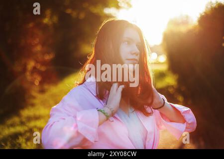 Nahaufnahme Porträt einer schönen jungen erwachsenen Frau im Sonnenlicht bei Sonnenuntergang Sie sonnt sich in der Sonne Stockfoto