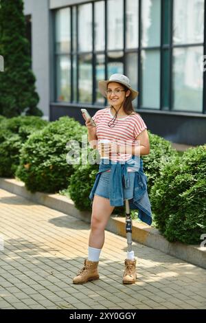 Eine junge Frau mit einer Beinprothese lächelt, als sie an einem sonnigen Tag durch einen Park spaziert. Stockfoto