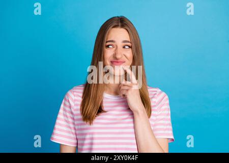 Foto der entzückenden schönen unzufriedenen Frau tragen stilvolle Kleidung aussehen leer Raum hmm isoliert auf blauem Hintergrund Stockfoto