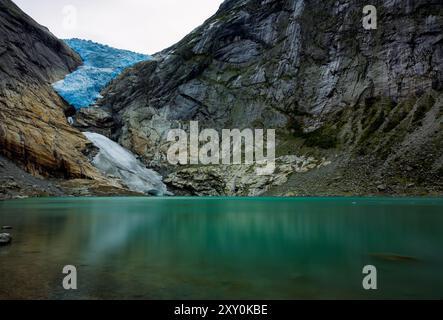 Panoramablick auf den Briksdalsbreen Gletscher mit dem Briksdalsvatn Schmelzwassersee im Vordergrund Stockfoto