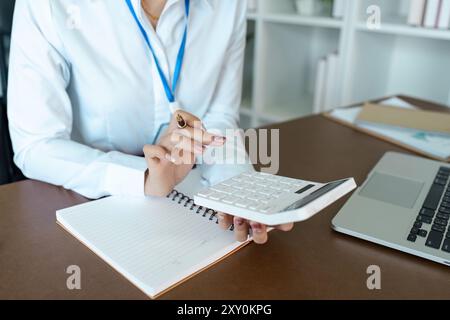 Professioneller Buchhalter, der mit Rechner und Notebook in moderner Büroumgebung arbeitet Stockfoto