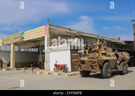 Azaz, Syrien. 11. Oktober 2019. Freie syrische Armeemitglieder bewachen Demonstranten von einem gepanzerten Fahrzeug am Grenzübergang Bab al-Salama im Nordosten Syriens, nahe der syrisch-türkischen Grenze. Syrer, die ursprünglich aus Dörfern stammen, die von den syrischen Demokratischen Kräften (SDF) und der kurdischen PKK-Partei kontrolliert wurden, demonstrierten im Nordosten von Azaz, um die türkische Militäroffensive „Friedensfrühling“ in Nordsyrien zu unterstützen. Sowohl Erwachsene als auch Kinder bekundeten ihre Unterstützung für die kürzlich begonnene Militäroperation der Türkei und der von der Türkei unterstützten Freien Syrischen Armee, die offiziell als syrische Nationalarmee bekannt ist Stockfoto