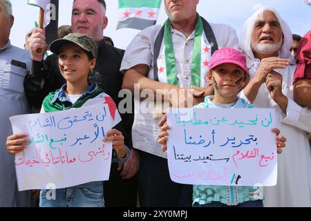 Azaz, Syrien. 11. Oktober 2019. Syrer, die ursprünglich aus Dörfern stammen, die von den syrischen Demokratischen Kräften (SDF) und der kurdischen PKK kontrolliert werden, demonstrieren durch den Grenzübergang Bab al-Salama im Nordosten Syriens, um die türkische Militäroffensive „Friedensfrühling“ in Nordsyrien zu unterstützen. Erwachsene und Kinder bekundeten ihre Unterstützung für die kürzlich begonnene Militäroperation der Türkei und der von der Türkei unterstützten Freien Syrischen Armee, offiziell bekannt als syrische Nationalarmee, östlich des Euphrats, und forderten die Befreiung ihrer Dörfer und Städte. Mehr als 250.000 Menschen waren hier Stockfoto