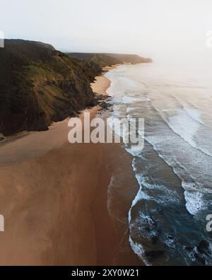 Von oben treffen die Küsten auf die Sandstrände der Algarve bei Sonnenuntergang in dieser ruhigen Landschaft Portugals. Stockfoto