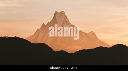 Eine ruhige Szene fängt die majestätischen Gipfel des Himalaya ein, die in den warmen Tönen der goldenen Stunde getaucht sind und eine ruhige und majestätische Landschaft schaffen. Stockfoto