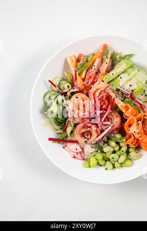 Blick von oben auf die Salmon Poke Bowl mit Lachs und Avocado auf weißem Hintergrund Stockfoto