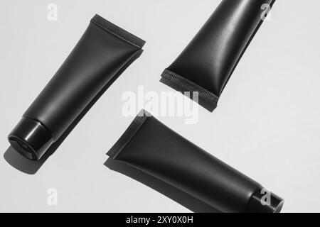 Elegante schwarze Kosmetikröhrchen mit mattem Finish, präsentiert auf einem sauberen weißen Hintergrund für ein minimalistisches Design. Stockfoto