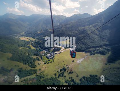 Eine atemberaubende Luftperspektive auf üppige Täler und Berge von der Seilbahn Fuente de in Picos de Europa, die grüne Landschaften und Distanz zeigt Stockfoto