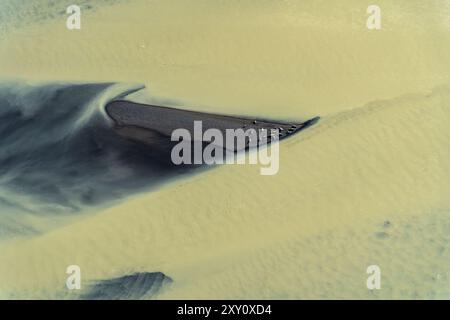 Abstrakte Luftaufnahme, die die dynamischen Texturen und Farben eines Gletscherflusses an der Südküste Islands und eine Gruppe von Robben einfängt und hervorhebt Stockfoto