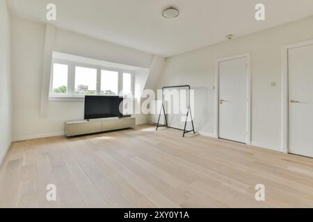 Ein helles und luftiges Wohnzimmer mit großen Fenstern, minimalen Möbeln und klaren Designlinien. Stockfoto