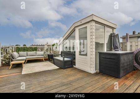 Eine stilvolle Dachterrasse mit gemütlichen Gartenmöbeln, Terrassen und einem klaren Himmel darüber. Stockfoto