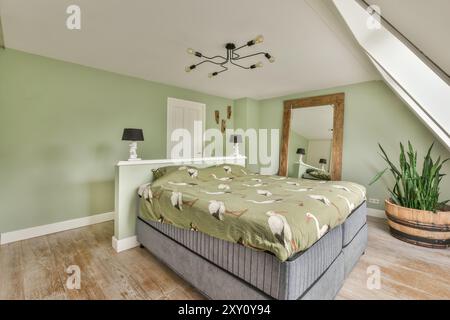 Modernes und stilvolles Schlafzimmer mit grünen Wänden, modernen Möbeln, breitem Spiegel und einzigartiger Deckenleuchte. Stockfoto