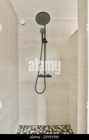 Moderne Dusche mit großem Kopf und Handbrause in einem sauberen, gefliesten Badezimmer. Stockfoto