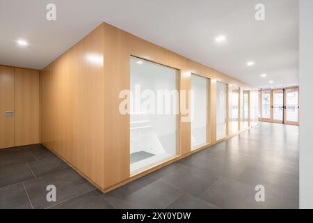 Dieser Saal mit Holzpaneelen, Glastüren und elegantem Fußboden zeichnet sich durch ein modernes Design aus. Stockfoto