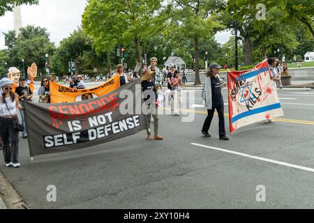 Washington DC, USA - 19.08.2024: Eine Gruppe von Menschen marschiert die Straße hinunter mit Schildern, auf denen steht: "Völkermord ist keine Selbstverteidigung." Stockfoto