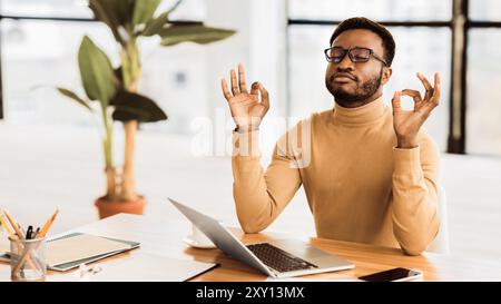 Ruhige schwarze Kerl meditieren während Hausaufgaben Stockfoto
