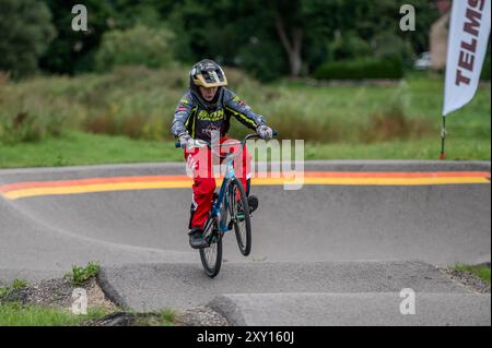 Tukums, Lettland - 10. August 2024: Ein Radfahrer fährt geschickt auf einem gewundenen Pumpweg, umgeben von Grün Stockfoto