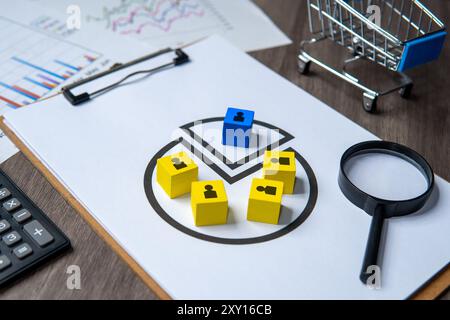 Ein Arbeitsbereich mit Diagrammen, bunten Blöcken, einer Lupe und einem Rechner. Marktsegmentierung, Kundenprofil-Konzept. Stockfoto