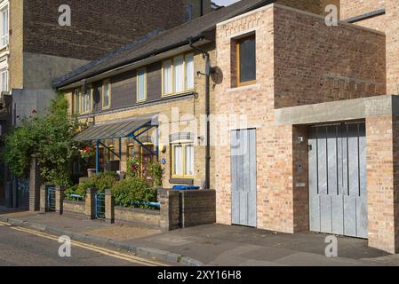 Elegantes Wohngebäude in Borough an einem sonnigen Tag mit vielen Pflanzen und Blumen im kleinen Vorgarten. London - 26. August 2024 Stockfoto