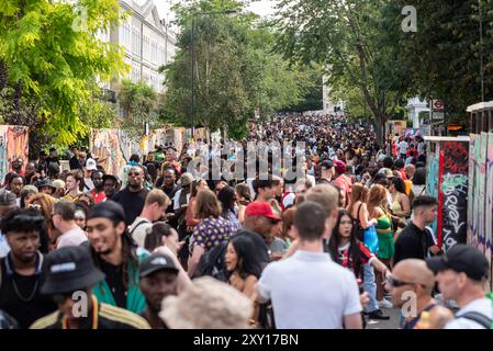 Menschenmassen kommen an der Notting Hill Carnival Grand Parade 2024 an. Erwachsenentag am Montag an Feiertagen. Eine große Anzahl von Menschen, die zum Karneval gehen Stockfoto