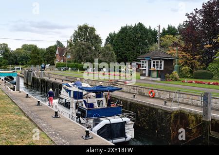 Vergnügungsboot, das an einem Sommertag durch Shepperton Schleuse fährt, Surrey England Großbritannien Stockfoto