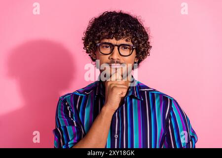 Foto des netten jungen Mannes Handberührung Kinnwand tragen Hemd isoliert auf rosa Hintergrund Stockfoto