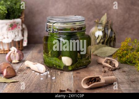 Halbsaure Dill-Gurken (schnell eingelegte Gurken) in einem Glas mit Gewürzen, Gewürzen und Kräutern. Hausgemachte saisonale Zubereitungen. Traditionelle Konservierung von Gemüse Stockfoto