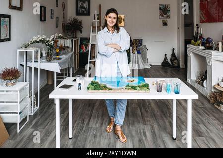 Ein junger Künstler, der während eines kreativen DIY-Projekts Epoxidharzkunst in einem hellen Atelier mit farbenfrohen Kunstwerken kreiert Stockfoto